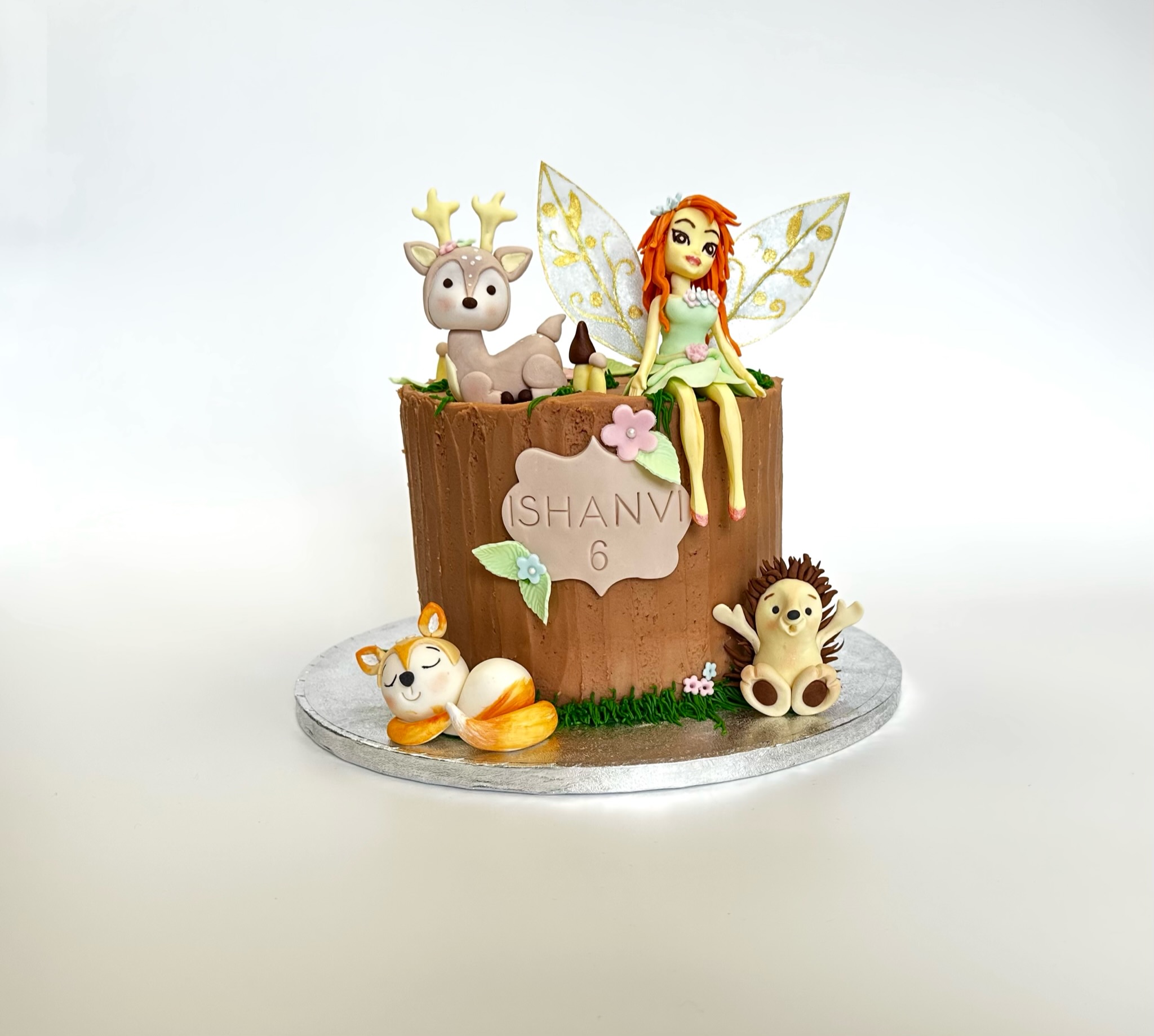 Birthday cake for children in woods style with a fairy, a hedgehog, a fox and a deer