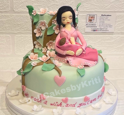 Baby Shower Cake with an edible mom figure holding a baby