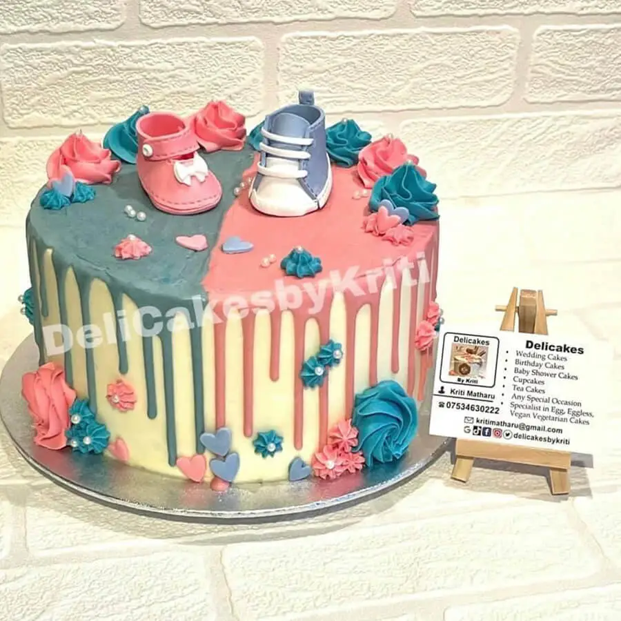 Baby Shower Cake with edible baby shoes on top of it